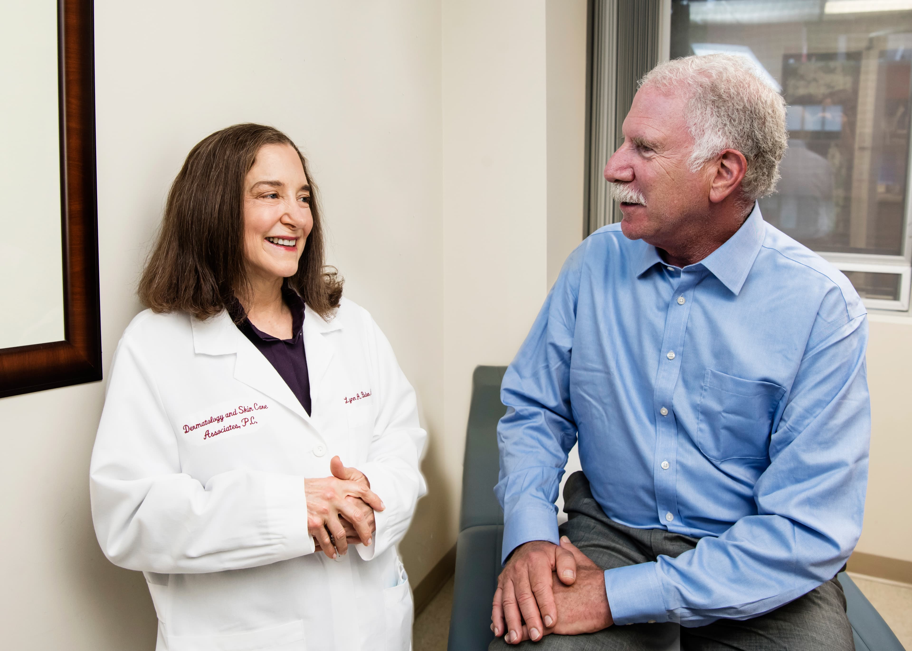 Dr. Lynn Baden in conversation with a patient during a consultation by the window