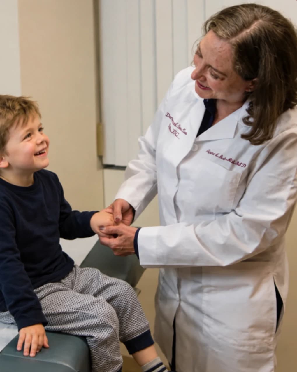 Dermatologist examining a young child in the exam room